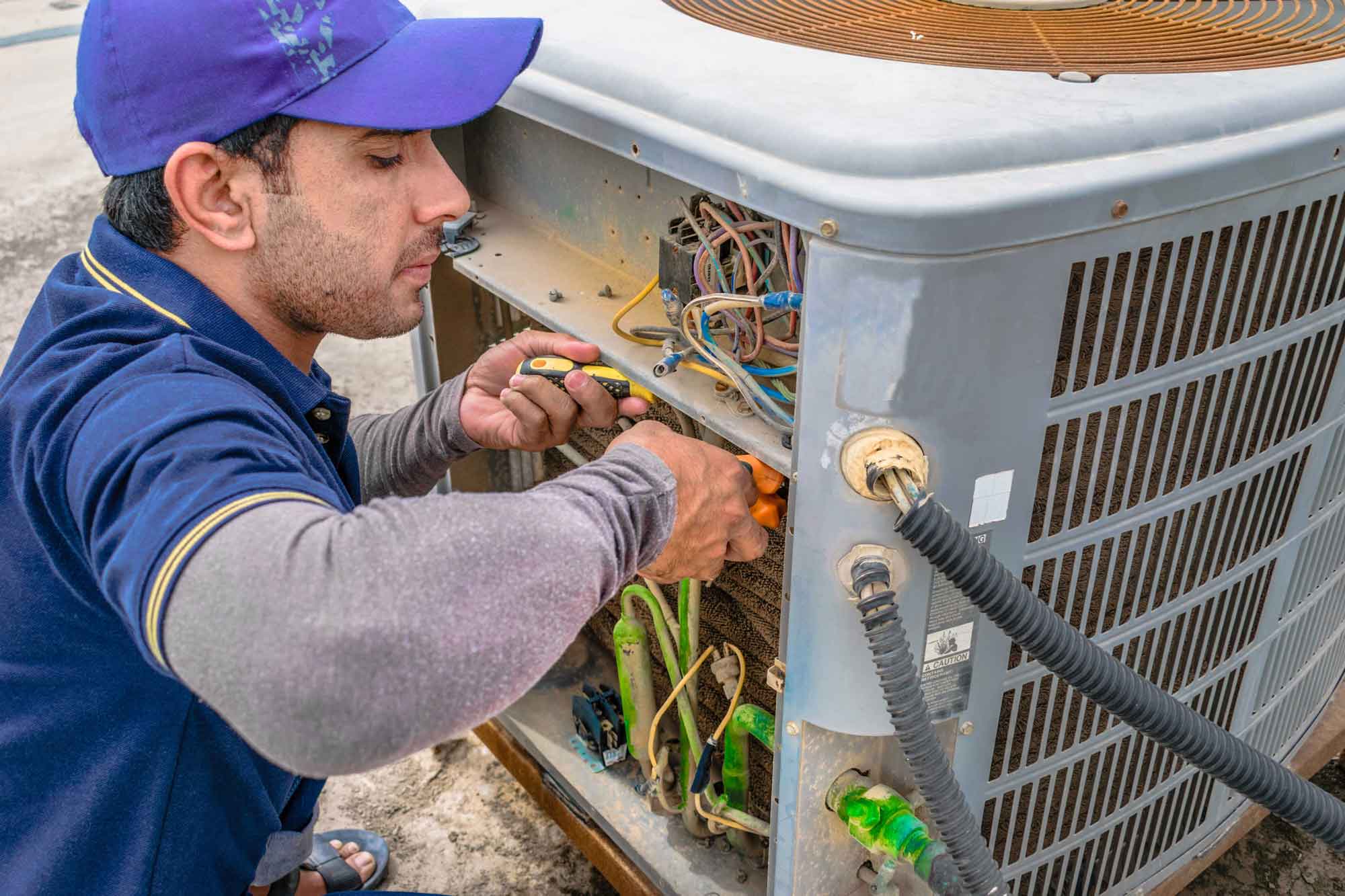 Technician performing air conditioning maintenance